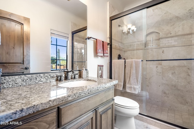 bathroom featuring a shower with door, vanity, and toilet