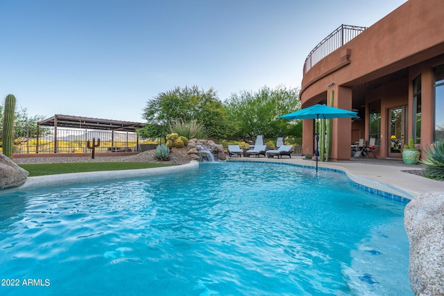 view of swimming pool featuring pool water feature and a patio