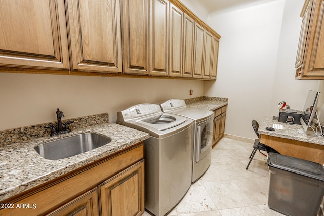 clothes washing area with sink, light tile patterned floors, washer and clothes dryer, and cabinets