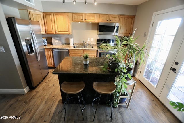 711 W El Alba Way, Chandler, AZ 85225 - kitchen with stainless steel appliances, a sink, light wood-style flooring, dark stone countertops, and light brown cabinets