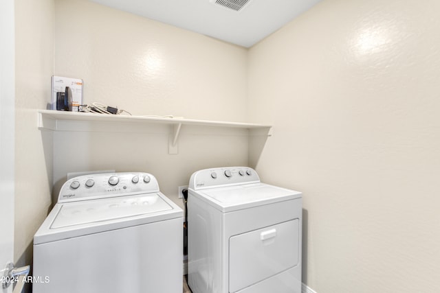 clothes washing area with washer and clothes dryer