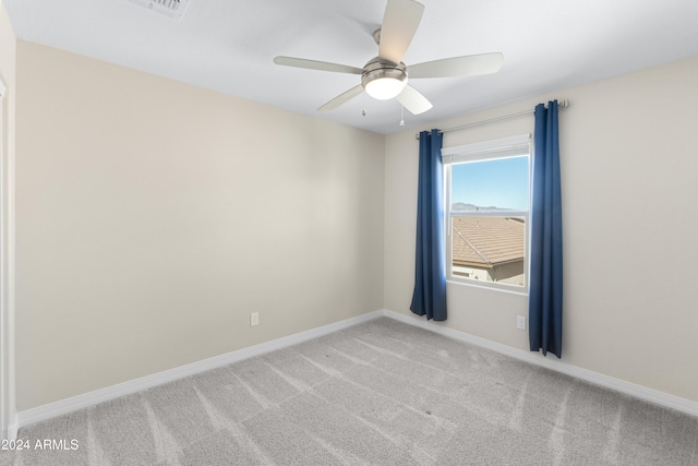 carpeted spare room featuring baseboards and ceiling fan