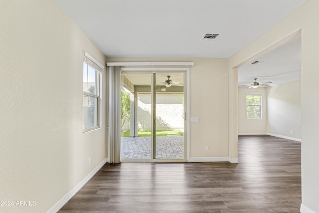 empty room with ceiling fan, dark wood-type flooring, and baseboards