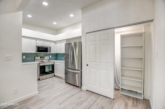7300 N Dreamy Draw Dr Unit 202, Phoenix, AZ 85020 - kitchen featuring stainless steel appliances, light countertops, light wood-style floors, tasteful backsplash, and recessed lighting