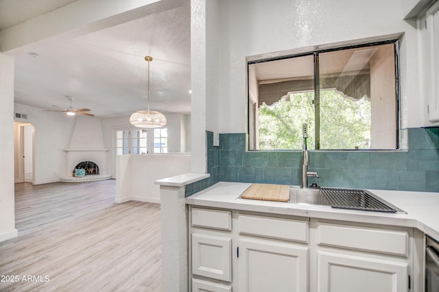 7300 N Dreamy Draw Dr Unit 202, Phoenix, AZ 85020 - kitchen with a ceiling fan, tasteful backsplash, white cabinets, light countertops, and light wood-style flooring