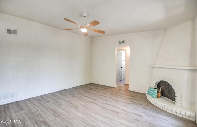 7300 N Dreamy Draw Dr Unit 202, Phoenix, AZ 85020 - unfurnished living room with a ceiling fan, arched walkways, wood finished floors, and a brick fireplace