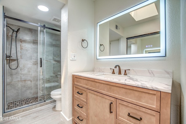 7300 N Dreamy Draw Dr Unit 202, Phoenix, AZ 85020 - bathroom featuring vanity, a shower stall, a skylight, and wood finished floors