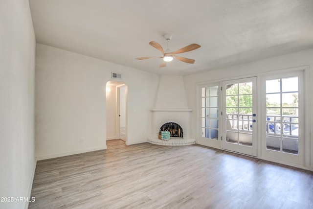 7300 N Dreamy Draw Dr Unit 202, Phoenix, AZ 85020 - unfurnished living room featuring ceiling fan, wood finished floors, arched walkways, and a brick fireplace
