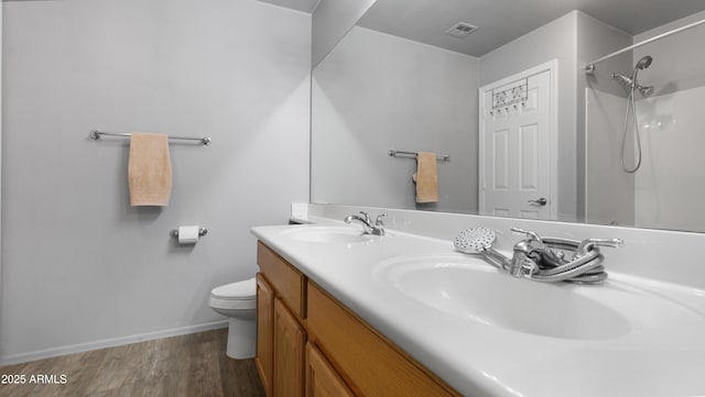 4073 E Stable Ct, Gilbert, AZ 85297 - bathroom featuring wood finished floors, toilet, a shower, baseboards, and double vanity