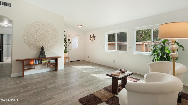 4073 E Stable Ct, Gilbert, AZ 85297 - sitting room featuring wood finished floors, vaulted ceiling, arched walkways, and baseboards