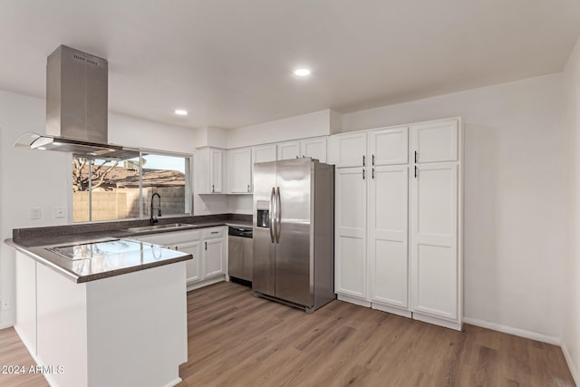 kitchen with kitchen peninsula, stainless steel appliances, sink, white cabinets, and light hardwood / wood-style floors