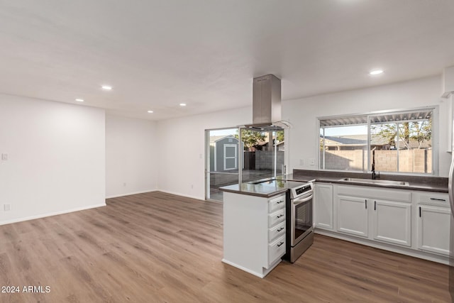 kitchen featuring stainless steel electric range, sink, white cabinetry, wood-type flooring, and island exhaust hood