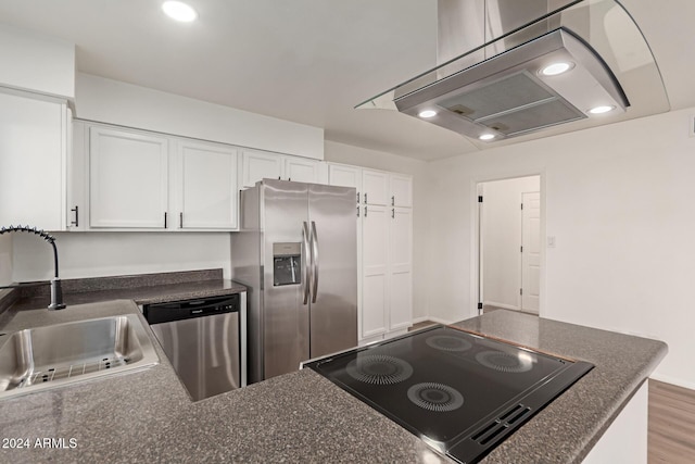 kitchen featuring island exhaust hood, stainless steel appliances, sink, hardwood / wood-style flooring, and white cabinets