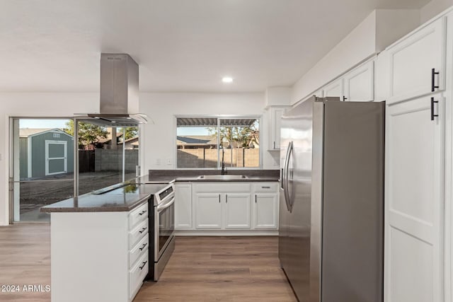 kitchen featuring white cabinetry, sink, stainless steel appliances, hardwood / wood-style floors, and island range hood