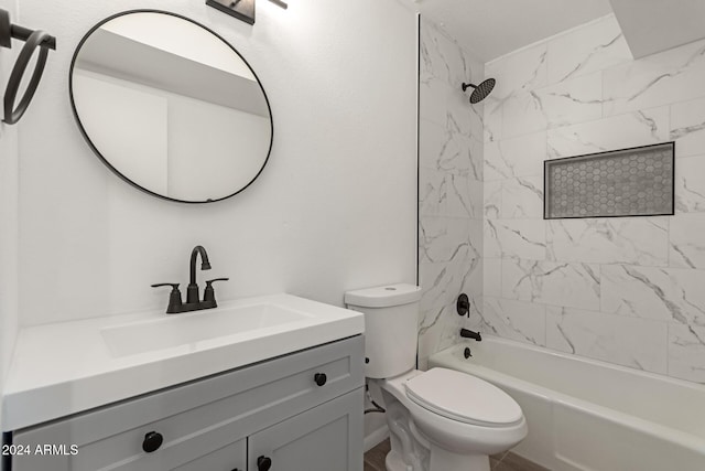 full bathroom featuring tiled shower / bath combo, toilet, and vanity