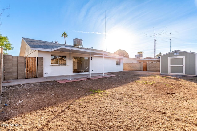 back of house featuring a patio area, a storage shed, and central AC