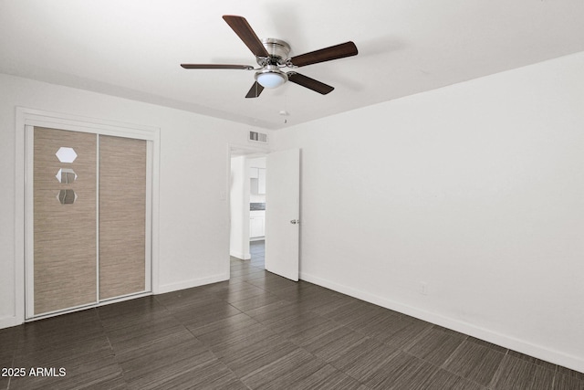 unfurnished bedroom with ceiling fan and a closet