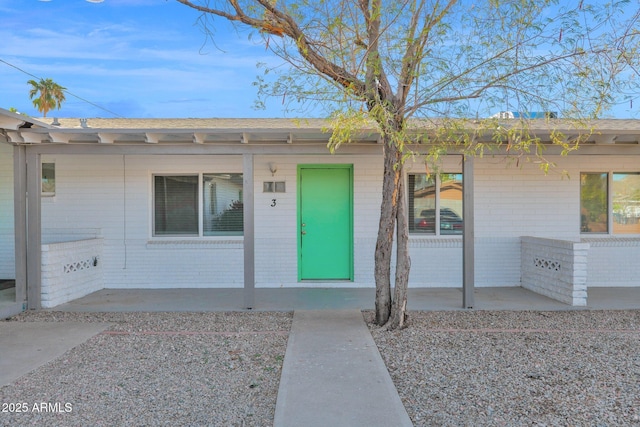 view of exterior entry with a patio