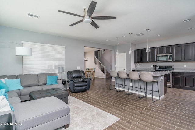 living room with ceiling fan, hardwood / wood-style flooring, and sink