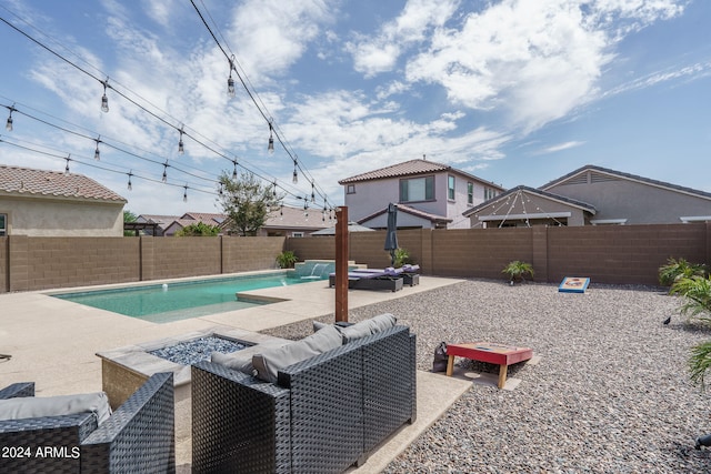 view of swimming pool with an outdoor living space, a patio, and pool water feature