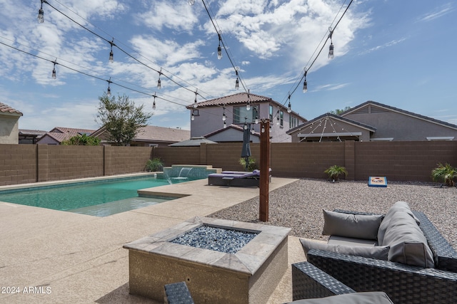 view of pool with an outdoor fire pit, a patio area, and pool water feature