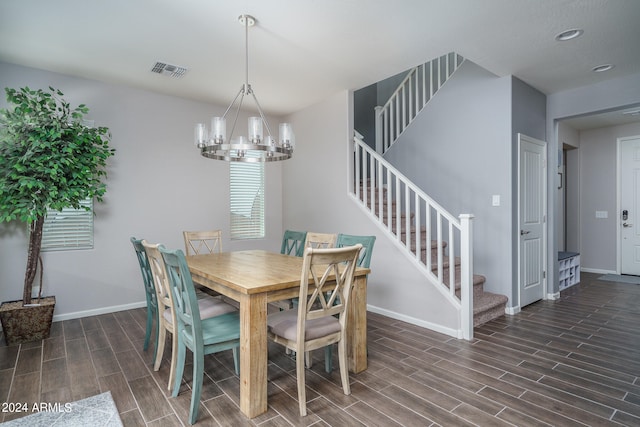 dining area featuring dark wood-type flooring and an inviting chandelier