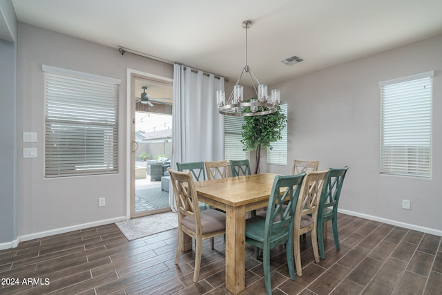 dining area featuring ceiling fan with notable chandelier and dark hardwood / wood-style flooring