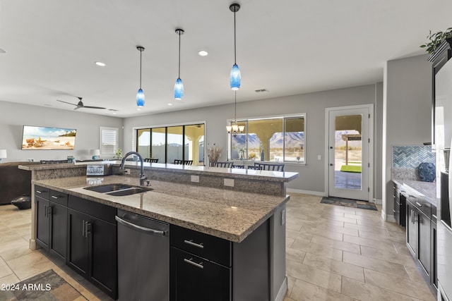 kitchen featuring ceiling fan with notable chandelier, a healthy amount of sunlight, dishwasher, and a kitchen island with sink