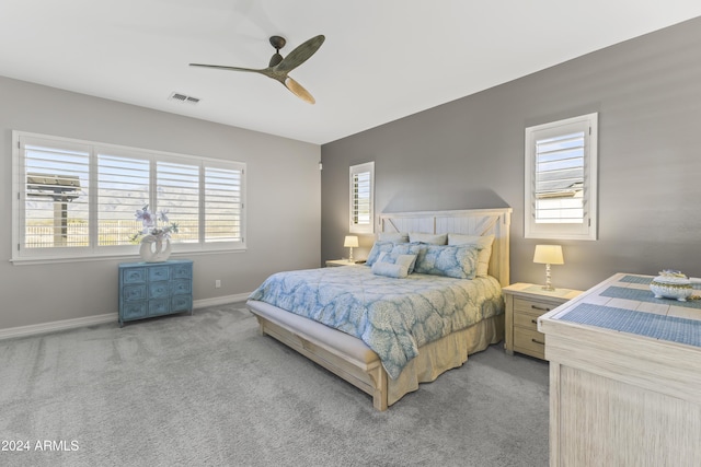 bedroom featuring light colored carpet, multiple windows, and ceiling fan