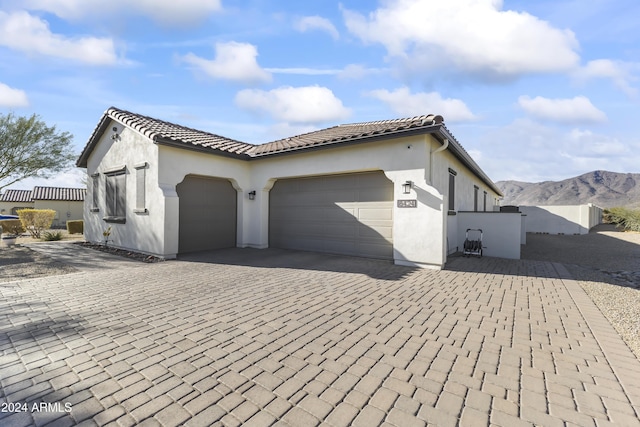 view of property exterior with a mountain view and a garage