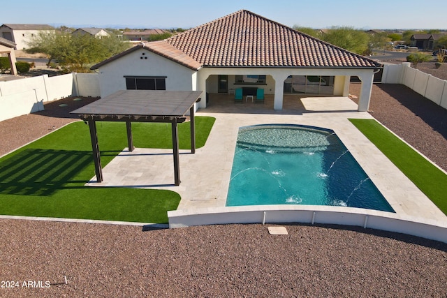 rear view of house featuring pool water feature, a fenced in pool, and a patio