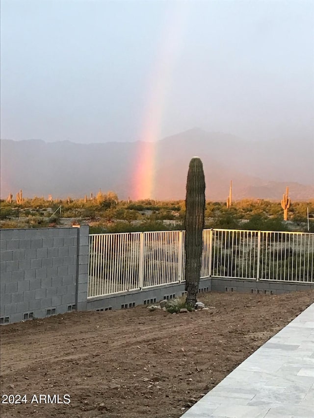 gate at dusk featuring a mountain view