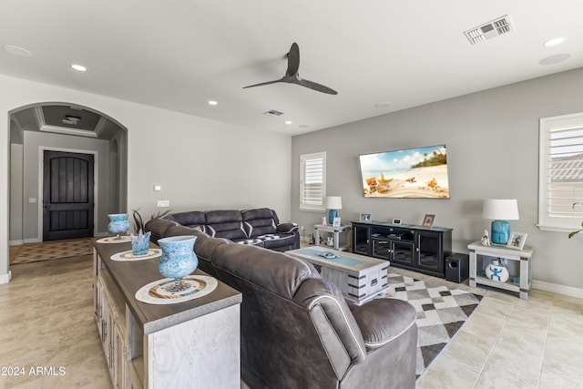 tiled living room with a wealth of natural light and ceiling fan