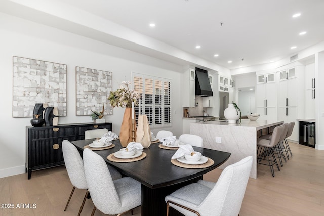 dining room featuring light wood-type flooring, recessed lighting, beverage cooler, and baseboards