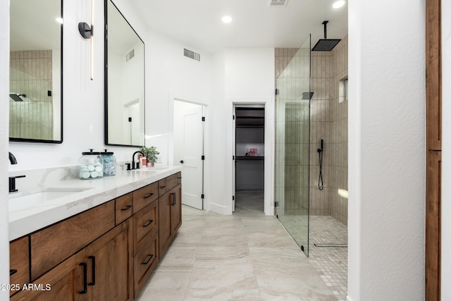 full bathroom with tiled shower, double vanity, and recessed lighting
