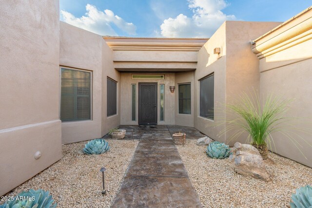 doorway to property featuring stucco siding