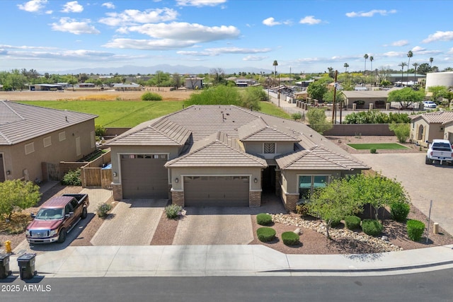 view of front of home featuring stucco siding, driveway, brick siding, a garage, and a tiled roof