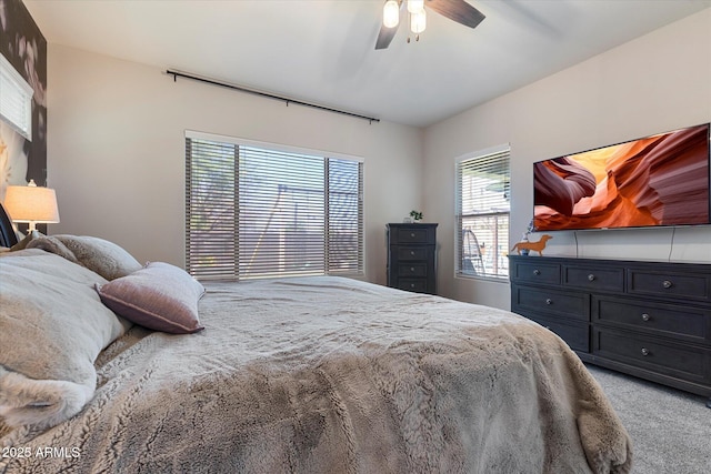 bedroom featuring light colored carpet and a ceiling fan