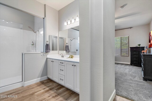 full bath with a shower stall, vanity, and baseboards