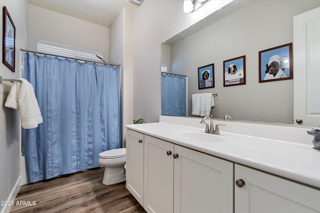 full bath featuring toilet, a shower with curtain, vanity, and wood finished floors