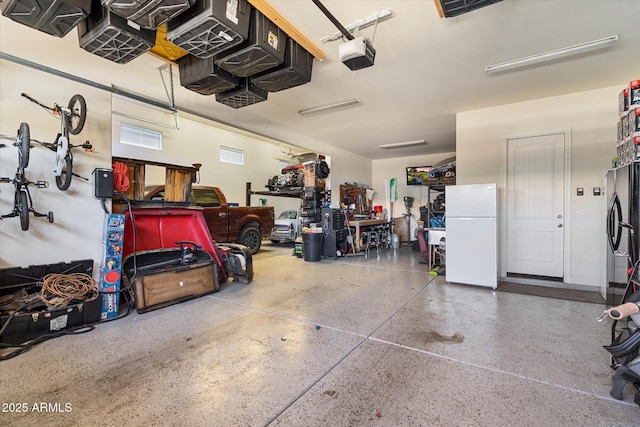 garage featuring a garage door opener and freestanding refrigerator