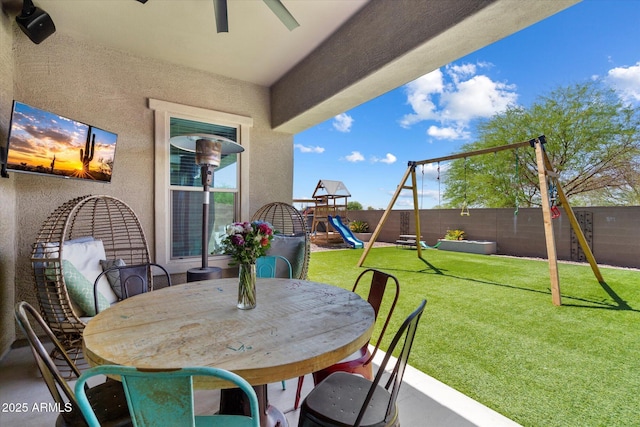 view of patio featuring outdoor dining area, a fenced backyard, and a playground