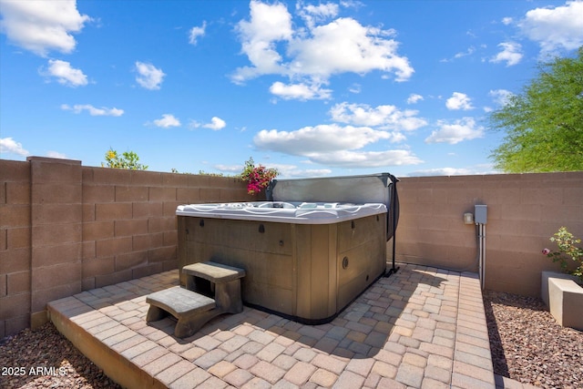 view of patio / terrace featuring a fenced backyard and a hot tub