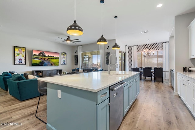 kitchen featuring stainless steel dishwasher, white cabinetry, visible vents, a sink, and open floor plan