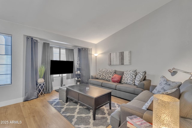 living room featuring lofted ceiling and light wood-type flooring