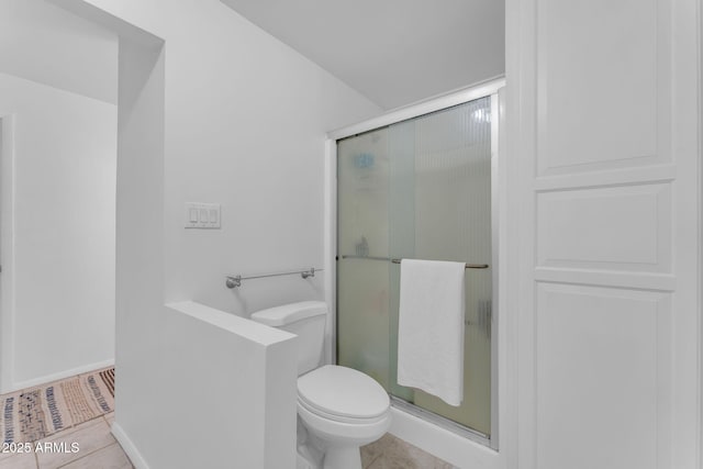 full bath featuring tile patterned flooring, baseboards, a shower stall, and toilet