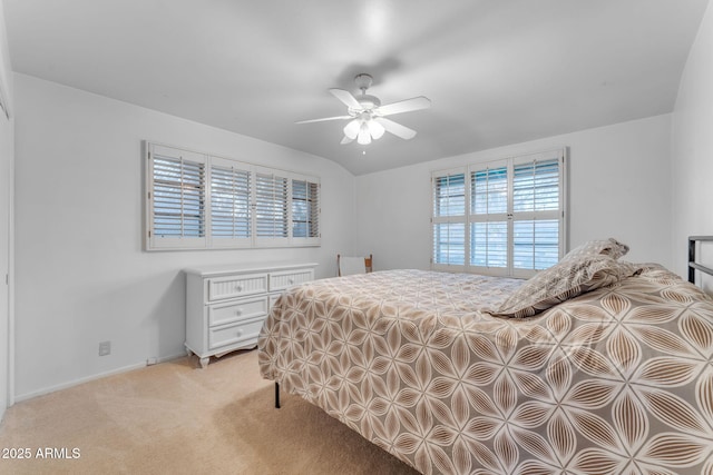 bedroom featuring light carpet, ceiling fan, baseboards, and lofted ceiling