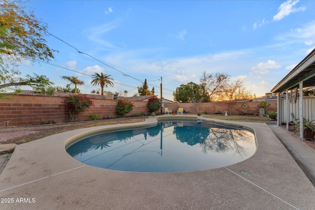 pool at dusk featuring a fenced in pool and a fenced backyard