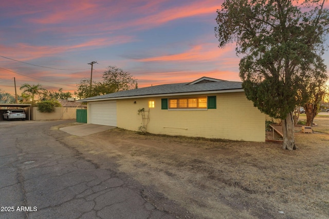 view of front of house featuring driveway, a carport, and an attached garage