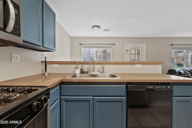 125 S 56th St Unit 27, Mesa, AZ 85206 - kitchen with dishwasher, stainless steel microwave, blue cabinetry, butcher block counters, and a peninsula